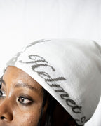 Person wearing a white helmet of salvation beanie. Side. Close-up. LOVE GOD BIG Christian clothing brand streetwear faith-based apparel.
