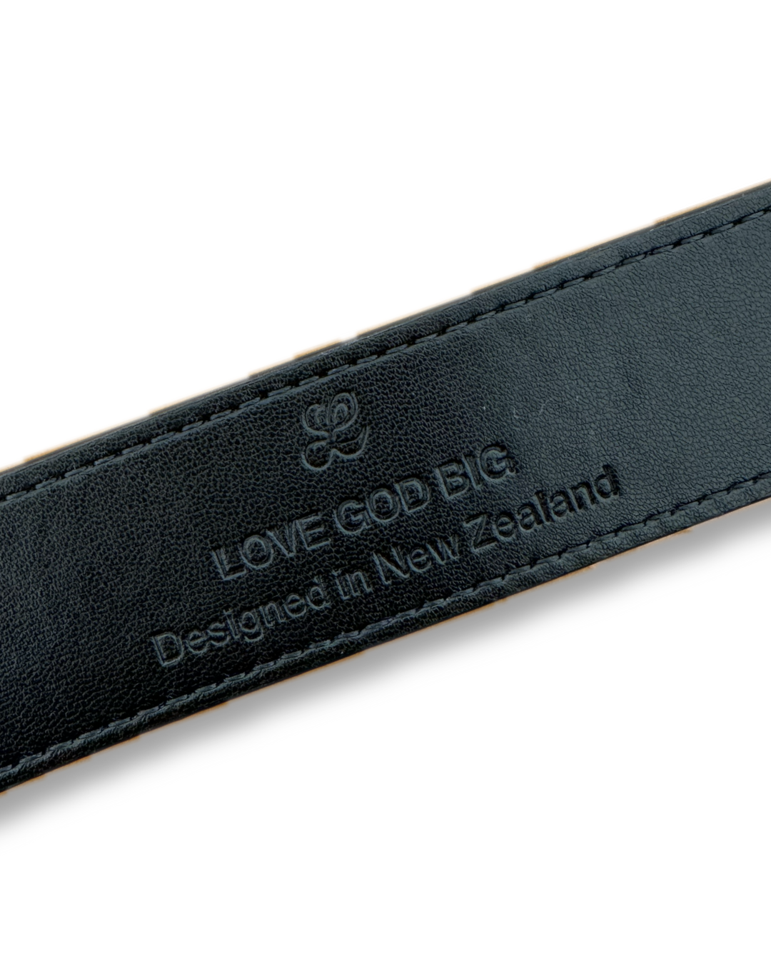 Black leather strap with 'LOVE GOD BIG' branding and text on a white background. LOVE GOD BIG Christian streetwear clothing brand. New Zealand Faith-based apparel.