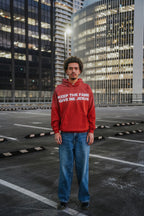 Person wearing a red Jesus vs Fame hoodie. Wide shot. LOVE GOD BIG Christian clothing brand streetwear faith-based apparel. New Zealand.