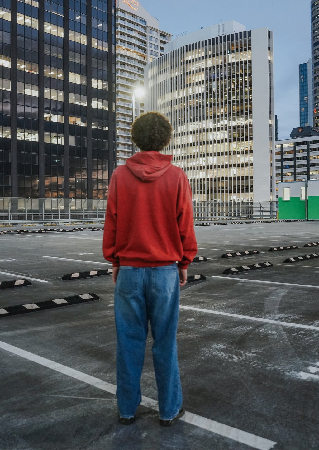 Person wearing a red Jesus vs Fame hoodie. Back. LOVE GOD BIG Christian clothing brand streetwear faith-based apparel. New Zealand.