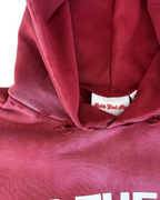 Close-up of a red Jesus vs Fame hoodie with neck distressing. Person wearing a red Jesus vs Fame hoodie. Wide shot. LOVE GOD BIG Christian clothing brand streetwear faith-based apparel. New Zealand.