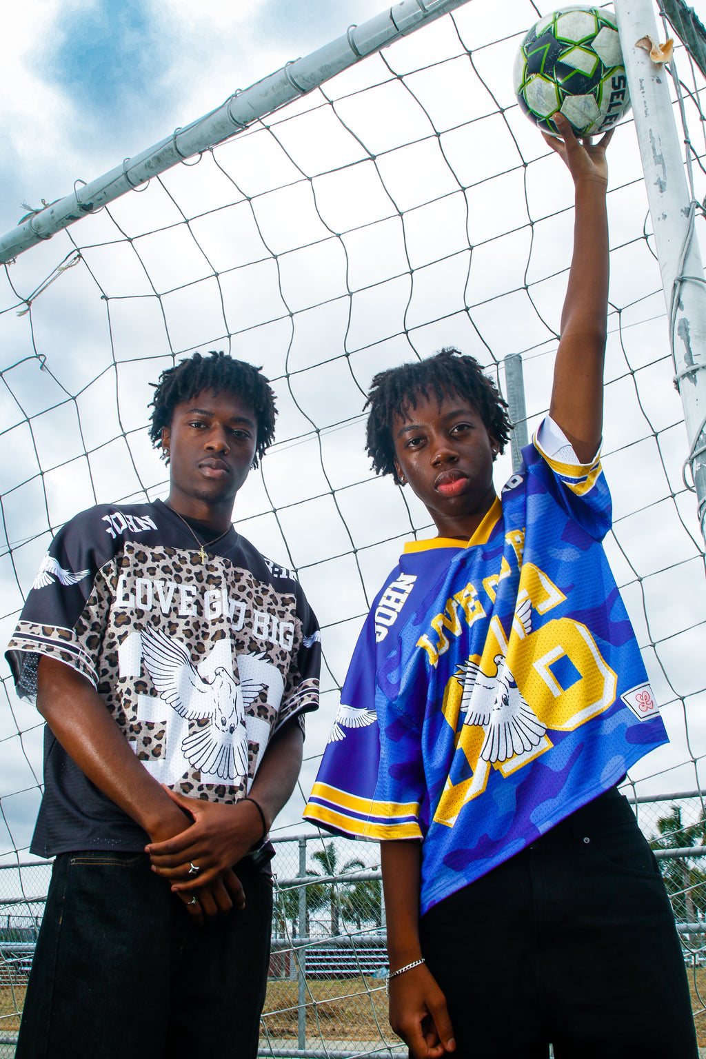 Two models wearing Saviour Football Jersey in black and blue from LOVE GOD BIG. Front. Designed in New Zealand.