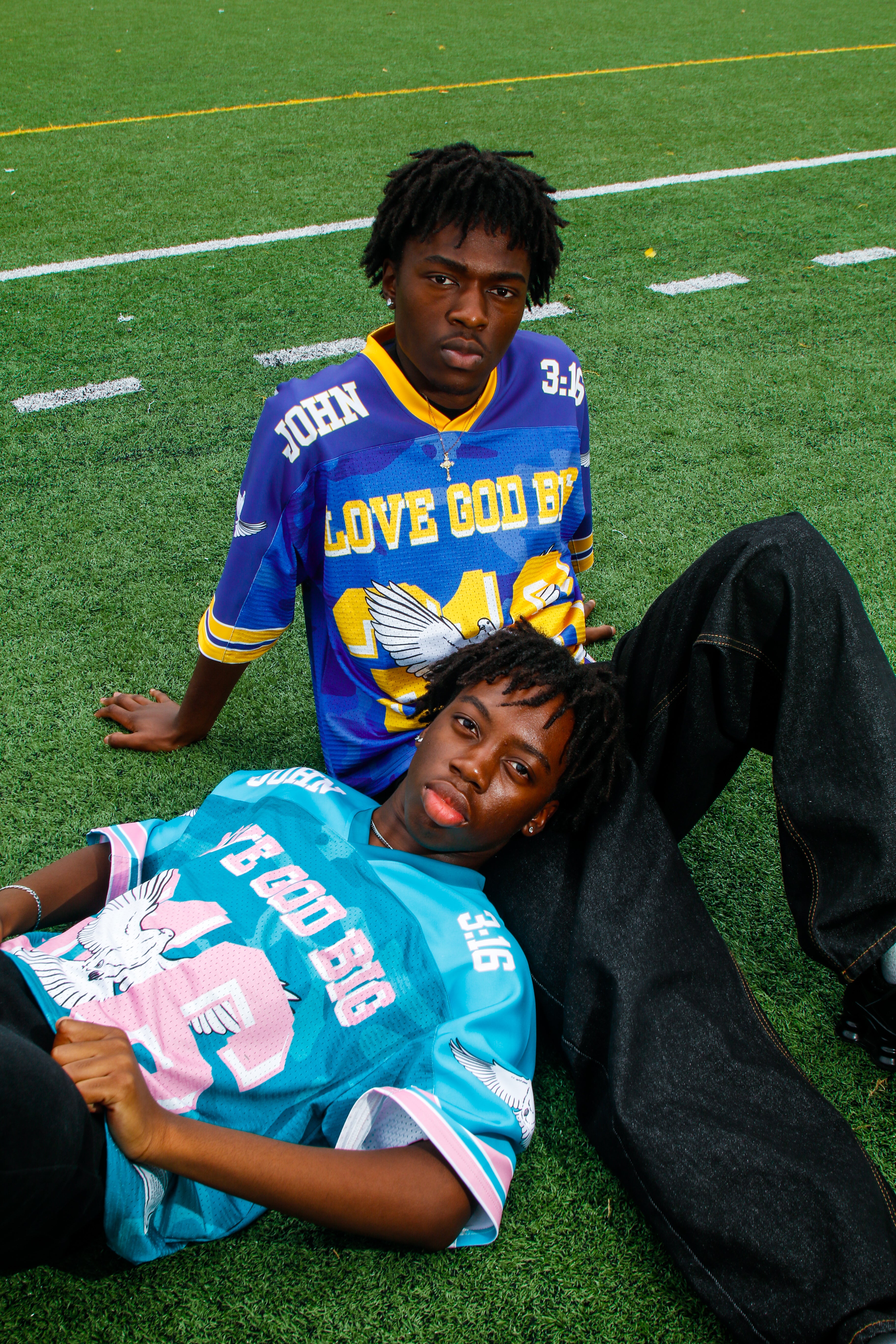 Two people wearing Saviour Football Jersey in Blue and Green from LOVE GOD BIG. Front. Designed in New Zealand.